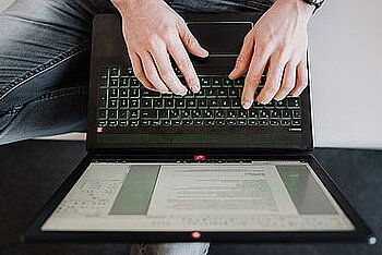Zwei Hände auf Laptoptastatur